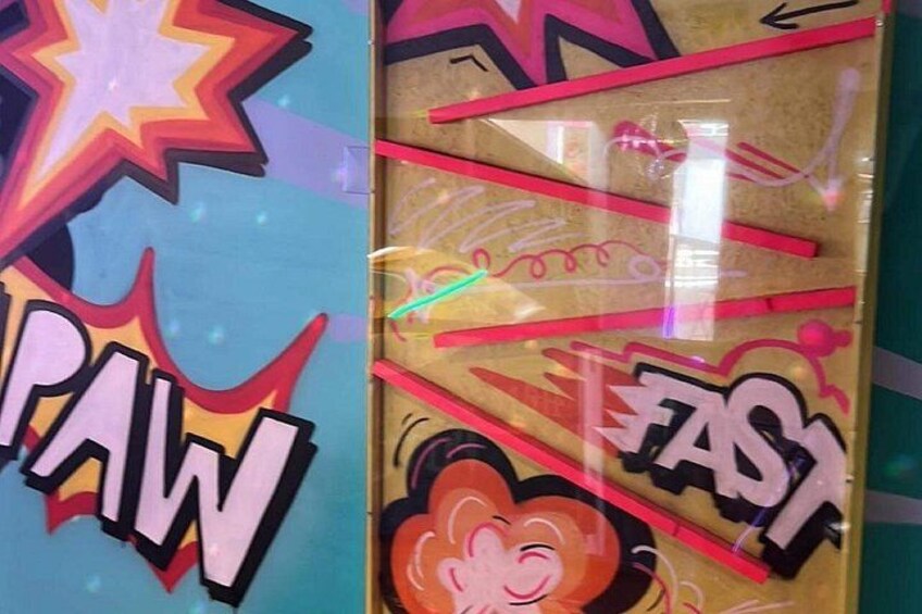 Un mur coloré orné de graffitis, avec les mots « PAW » et « FAST » ainsi qu’un dessin animé de singe. 3