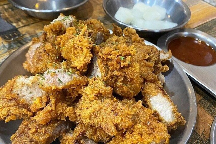 A plate of fried chicken with dipping sauce and onion rings. 2