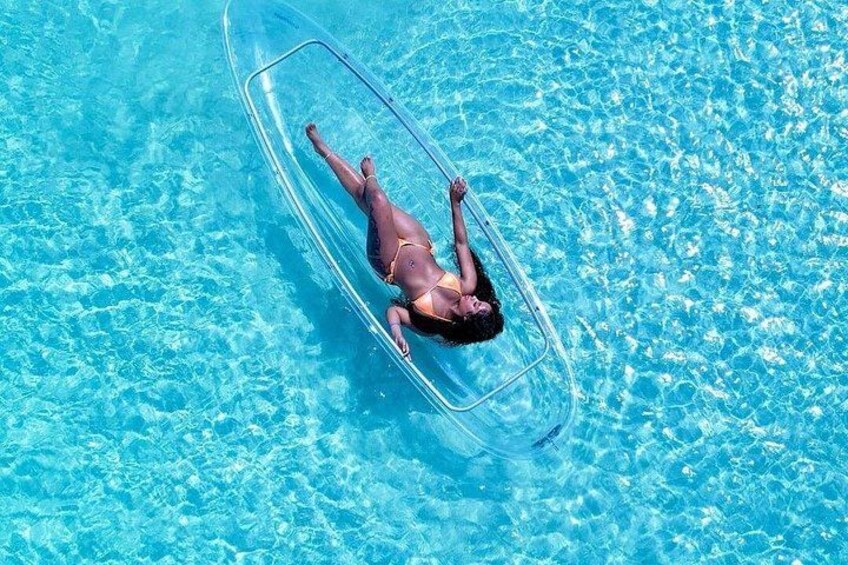 En person som flyter på en genomskinlig, uppblåsbar badring i en pool. 5