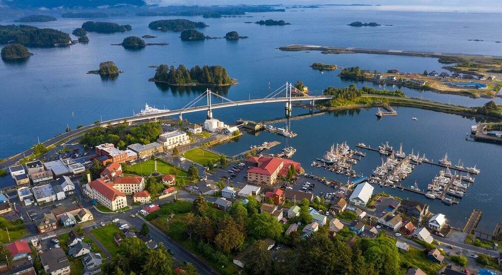 An aerial view of a coastal town with a prominent bridge, marina, and surrounding islands. 2