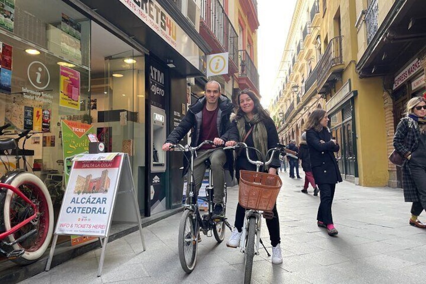 A person riding a bicycle with a basket on a city street. 1