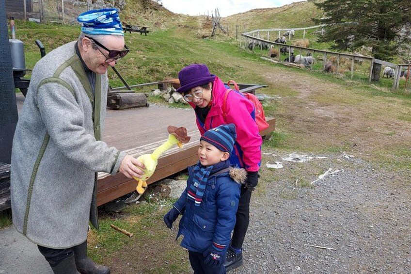 A person handing a toy to a child near a wooden bench in a park. 2