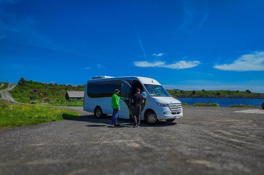 A white van parked on a road with a person standing next to it. 3