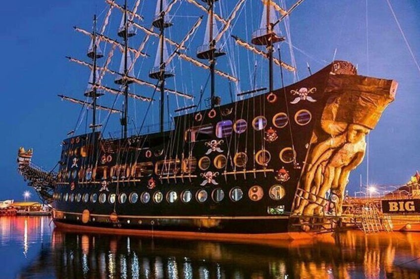 Un gran barco con varios mástiles y una figura ornamental, atracado en un puerto. 3