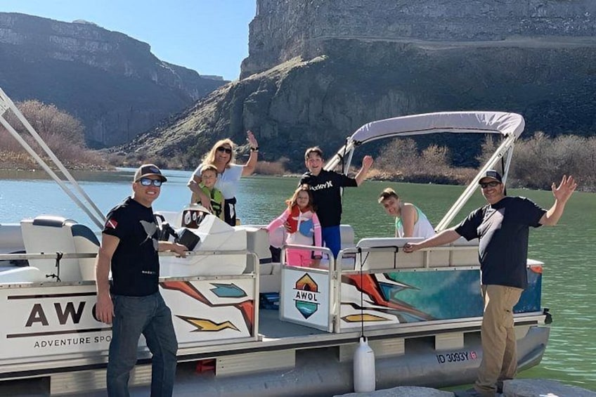 A group of people on a boat with a logo that reads 'AW Adventure Sports.' 3