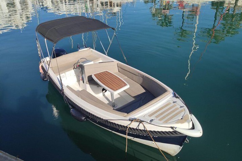 Ein Motorboot liegt an einem Jachthafen, mit einer Markise, einem Holzboden und einer Welle. 3