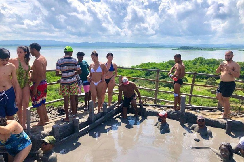 Un groupe de personnes se trouve dans une source thermale, avec une vue sur un lac et des montagnes en arrière-plan. 1