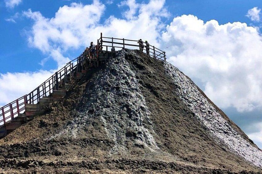 Une colline rocheuse surmontée d’un escalier et d’une rampe en bois menant au sommet. 4