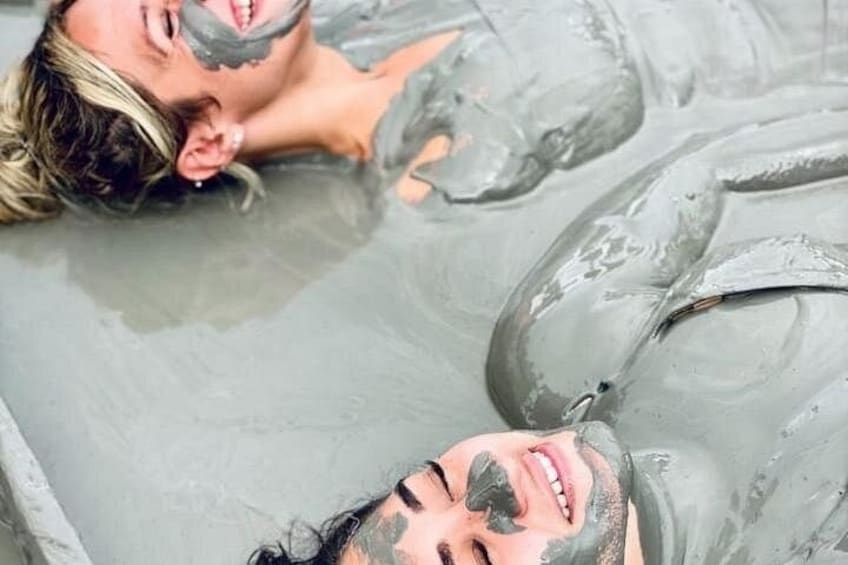 Deux personnes immergées dans une étendue d’eau, avec une substance grisâtre sur la peau. 5