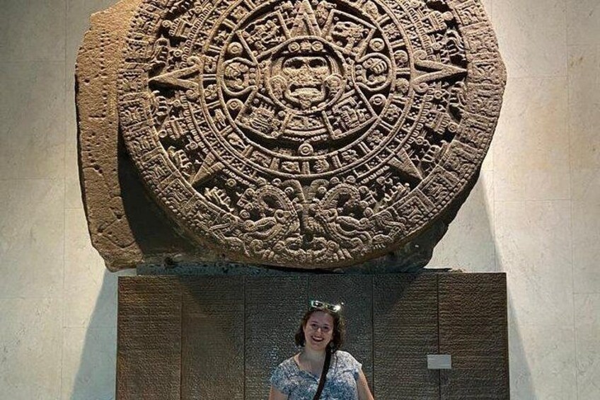 A large stone artifact with intricate carvings and a person standing in front of it. 2
