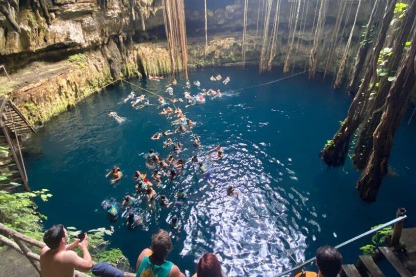 Eine Gruppe Menschen schwimmt in einem natürlichen Pool, umgeben von steilen Felsen. 5