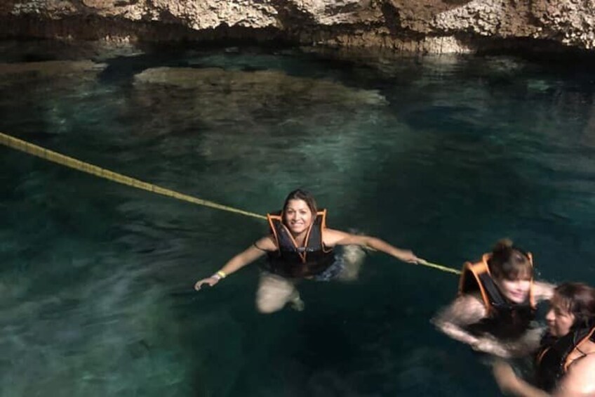 Eine Person in einem Schwimmbecken mit einem Seil, umgeben von Felsen. 4