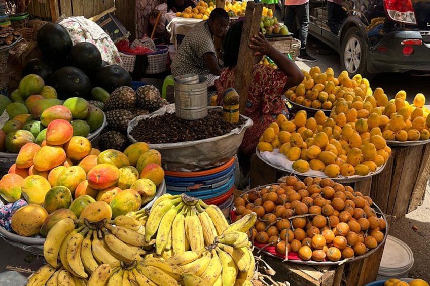 Un marché aux fruits où l’on peut trouver une variété de fruits, comme des bananes, des oranges et des mangues. 2