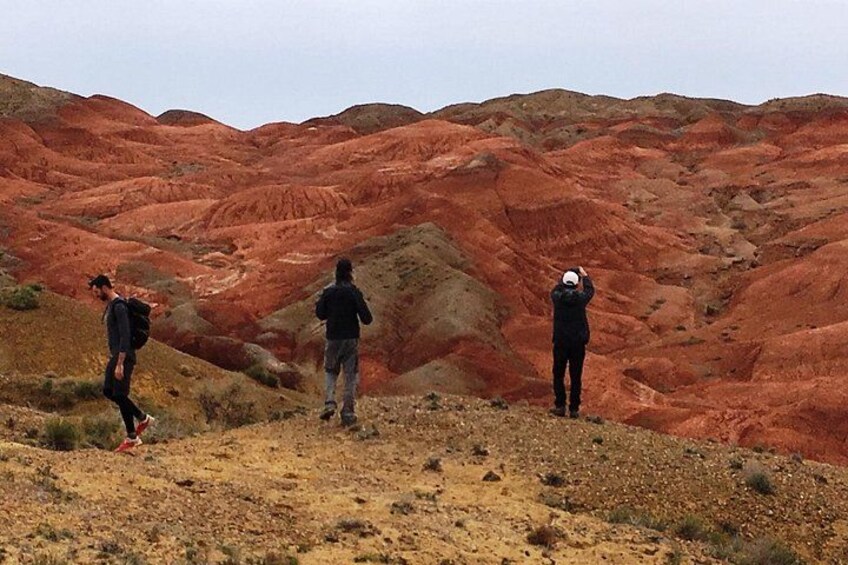 Three people hiking in a red-hued landscape. 2