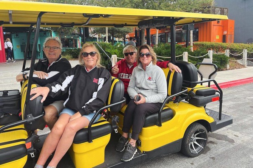 A yellow golf cart with four passengers. 3