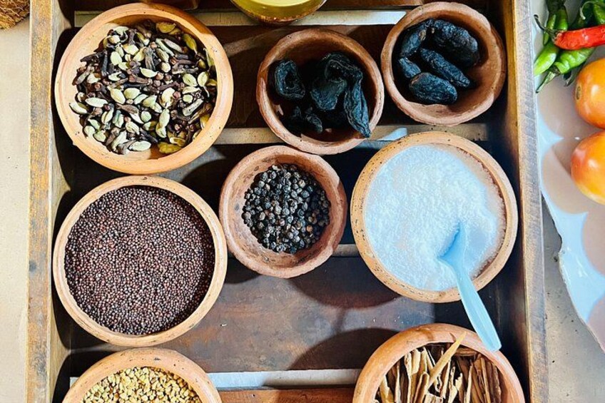 A wooden tray with various spices and seeds in bowls. 3