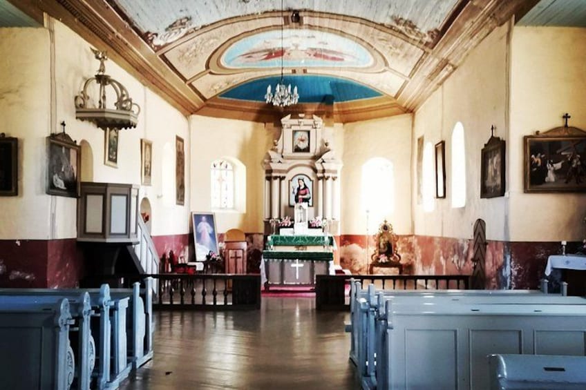 L’intérieur d’une église, avec ses bancs, son autel central et des œuvres d’art à thème religieux. 5