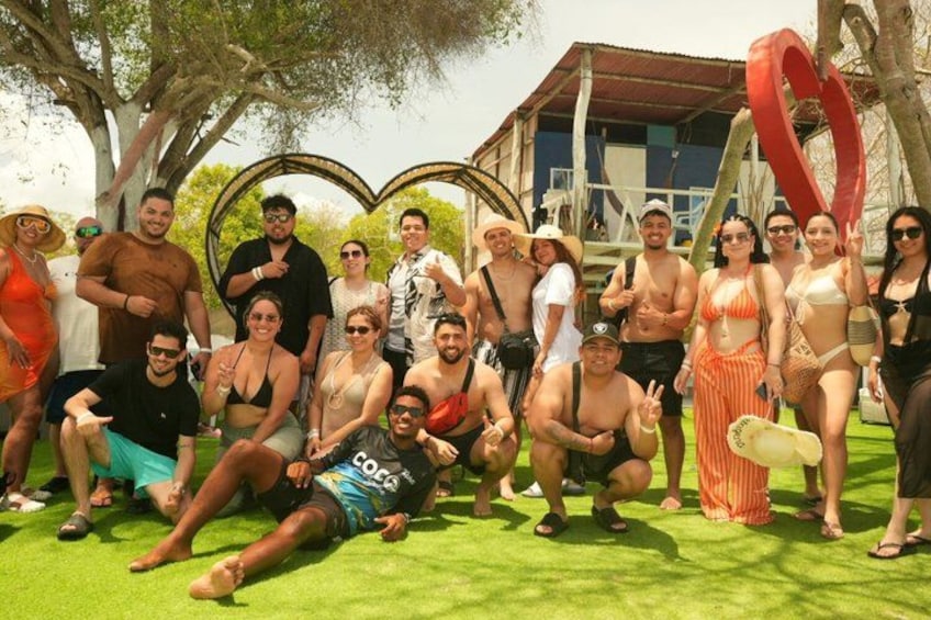 A group of people posing outdoors with a heart-shaped decoration and a building in the background. 5