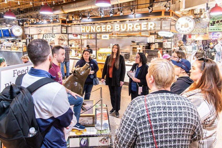 A food court with a 'HUNGER BURGER' sign, people standing in line, and a 'Feed the Hungry' sign. 3
