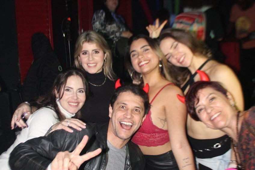Un grupo de personas posando juntas, algunas usando cuernos de diablo rojos. 2