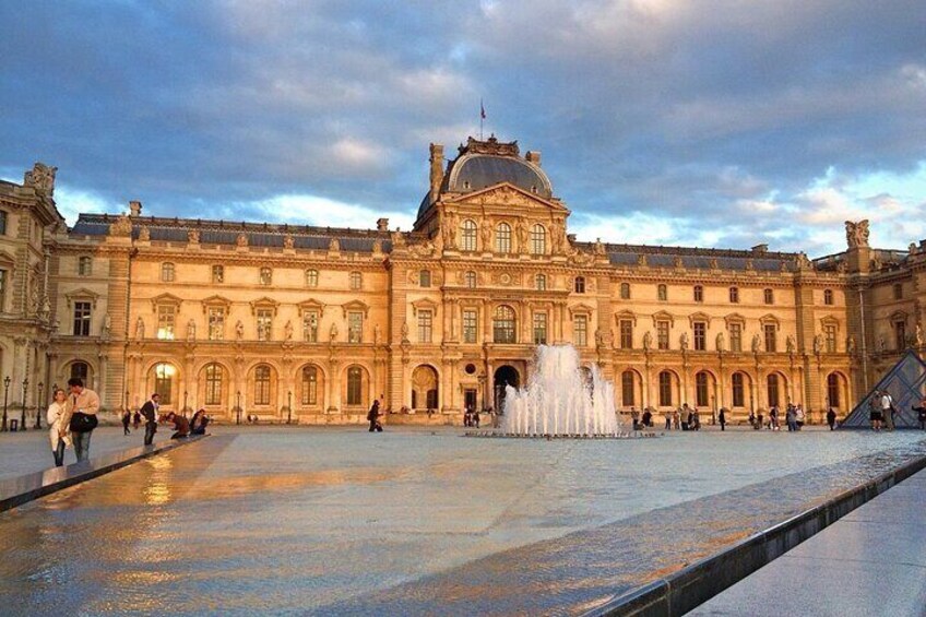 The Louvre Museum with its classical architecture and a large fountain in the courtyard. 5