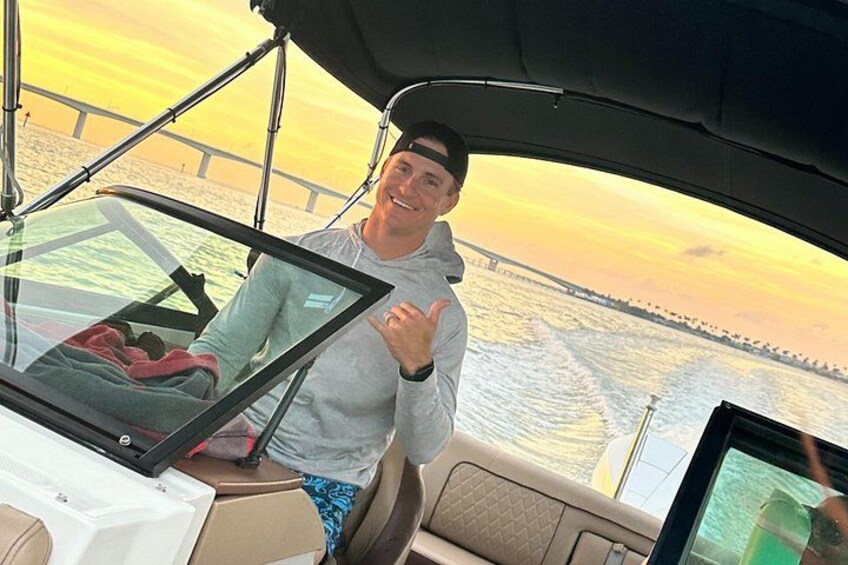 Iemand in een boot met uitzicht op een brug en zonsondergang. 2
