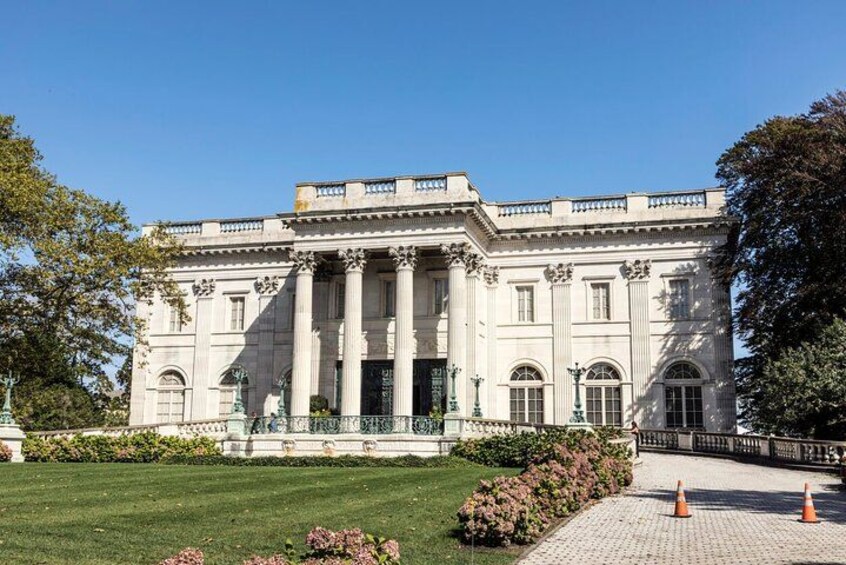 Un grand bâtiment de style classique, doté de colonnes et d’une façade symétrique. 2