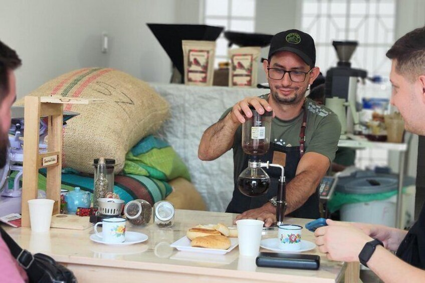 Une personne verse du café d’un récipient foncé dans un verre. 1