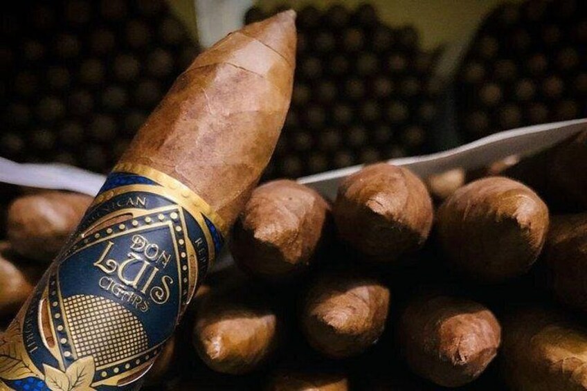 A cigar with a label and several cigars in the background. 1