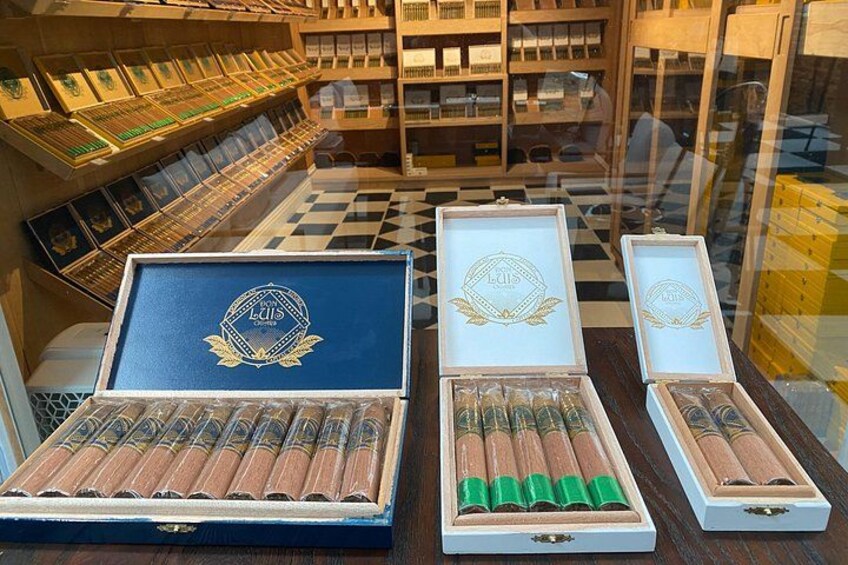 A cigar store with various cigar boxes and tubes on display. 3