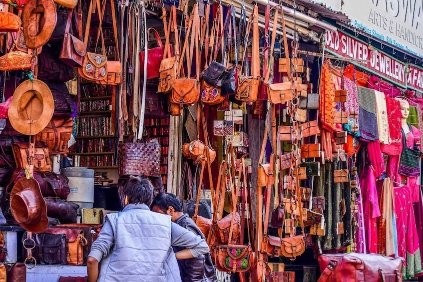 Un puesto de mercado con varias bolsas y textiles. 4