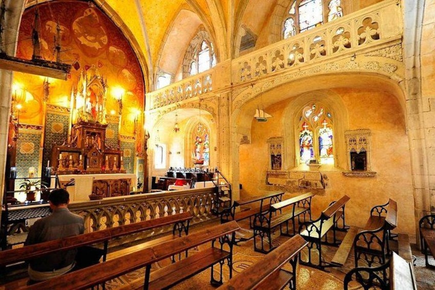 An interior of a cathedral with high arched ceilings, stained glass windows, and wooden pews. 4