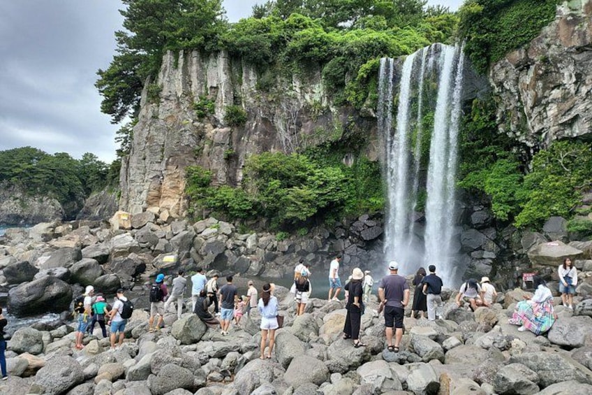 A waterfall cascading down a rocky cliff surrounded by lush greenery. 4