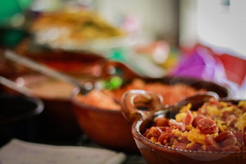 A variety of dishes in ceramic bowls, likely part of a buffet or communal meal setting. 5