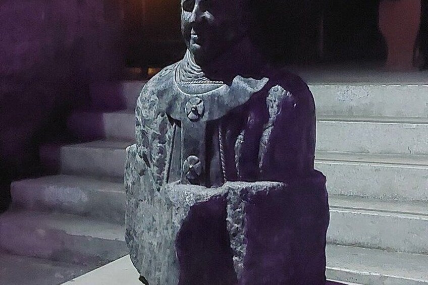 A statue with intricate carvings, positioned on steps. 3