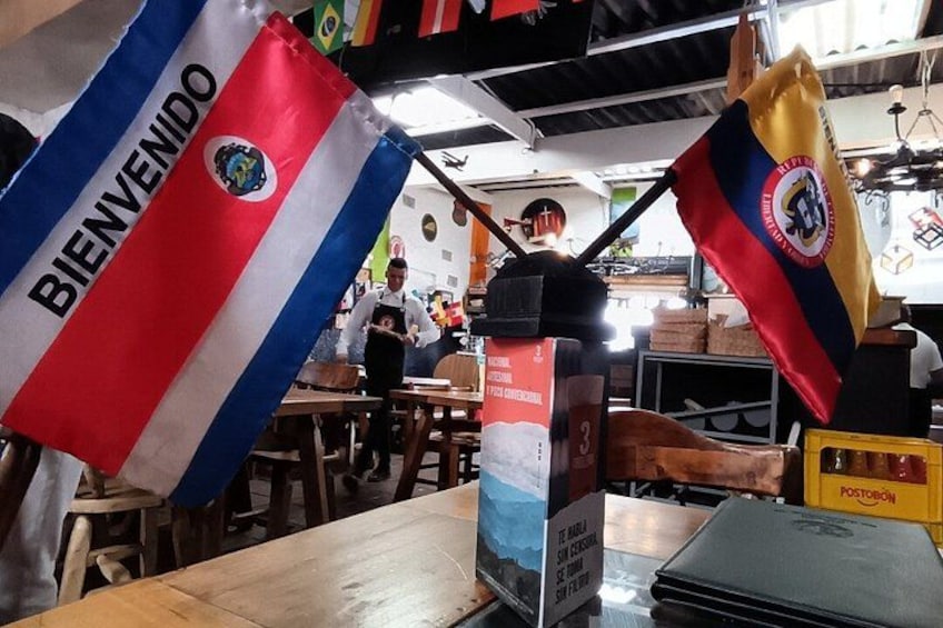 A restaurant interior with flags, a menu, and a post office box. 2