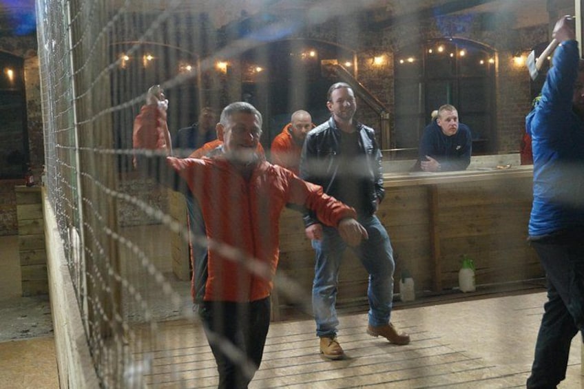 Un groupe de personnes se trouve dans un espace intérieur rustique, avec des murs en bois et un coin bar. 3