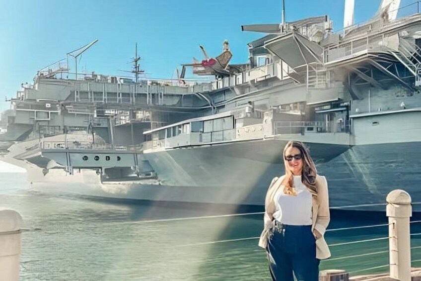 A person standing in front of a large ship with a dock in the background. 1