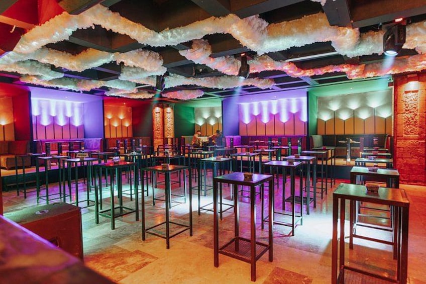A restaurant interior with multiple tables, chairs, and a ceiling with hanging decorations. 3