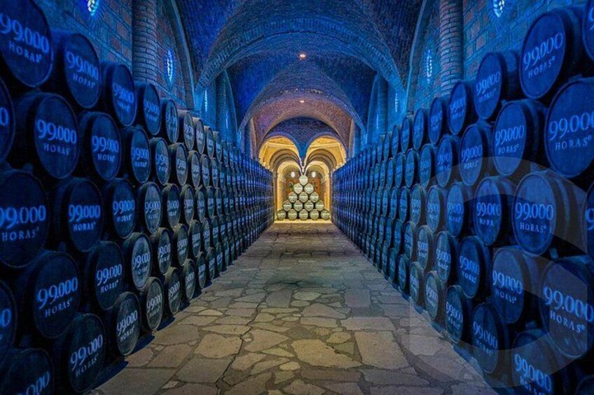 A corridor lined with barrels, leading to a central archway. 2