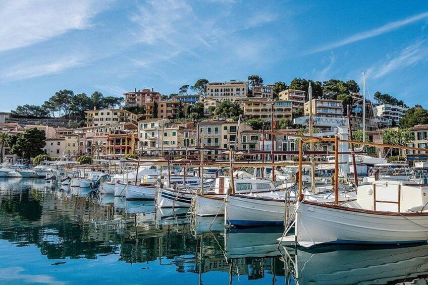 A marina with boats docked, a coastal town with buildings, and a clear sky. 2