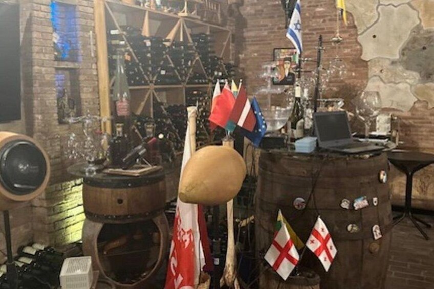 Un interior rústico con barriles de madera, banderas y una radio antigua. 3