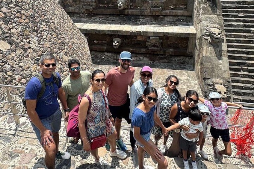 Un grupo de personas sobre una plataforma de piedra, con un muro y escalones de piedra al fondo. 5