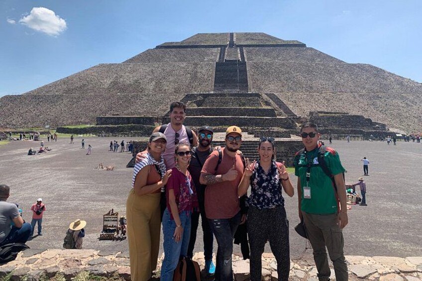 En gruppe mennesker poserer foran en stor pyramide. 3