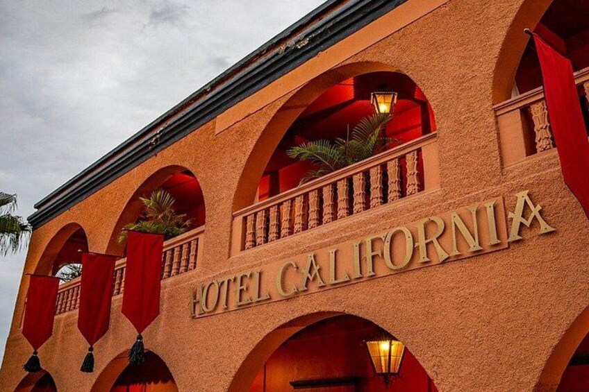 A building with arched windows and the sign 'HOTEL CALIFORNIA'. 4