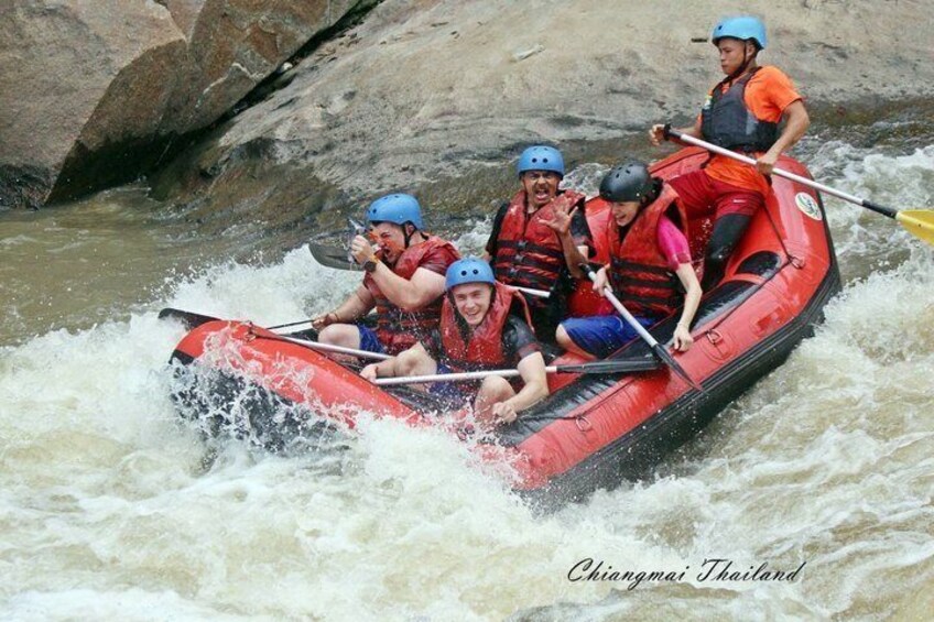 A group of people in a red raft navigating a river. 3