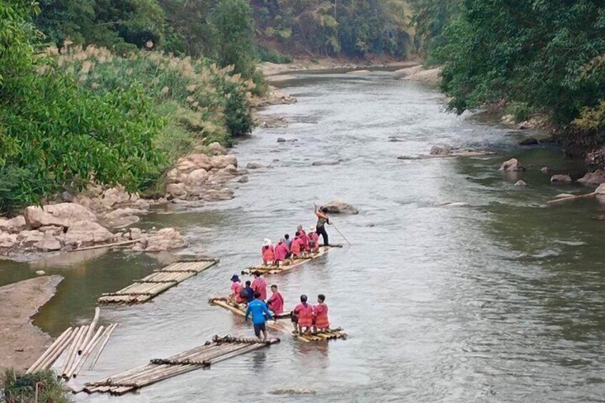 A river with people in boats and a wooden bridge. 5