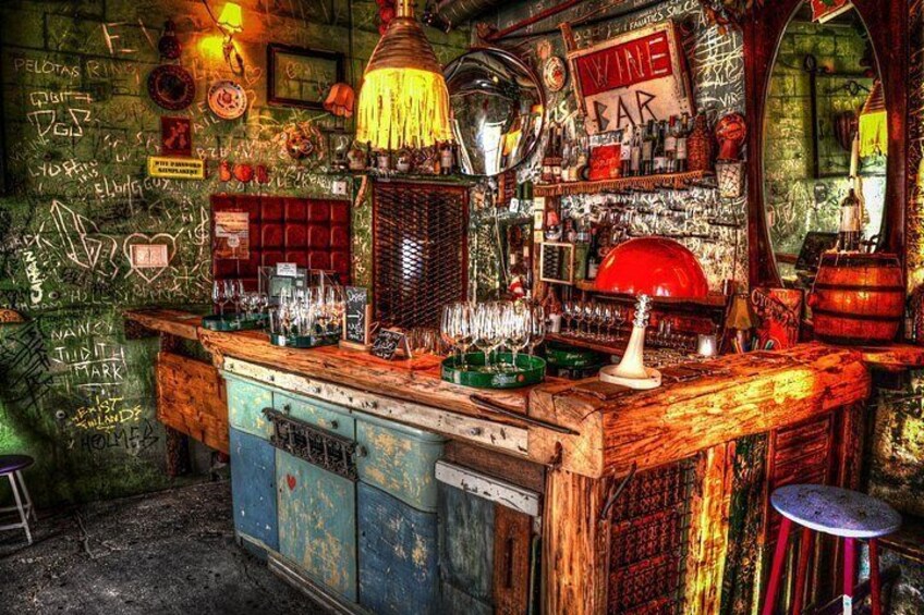 A bar with a vintage aesthetic, featuring a wooden counter, a red barrel, and various bar equipment. 1