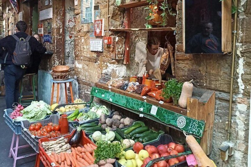 A street market with fresh produce, a vendor, and a customer. 4