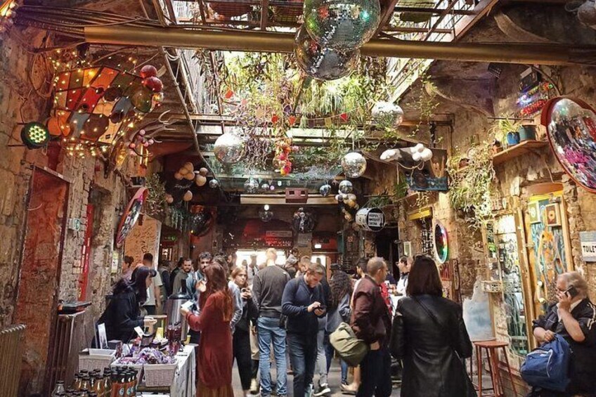 A crowded indoor market with various stalls and hanging decorations. 5